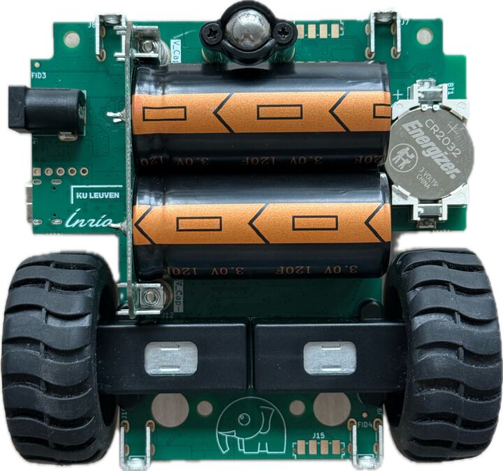 Photo of the underside of a DotBot v3 showing two orange-wrapped supercapacitors.