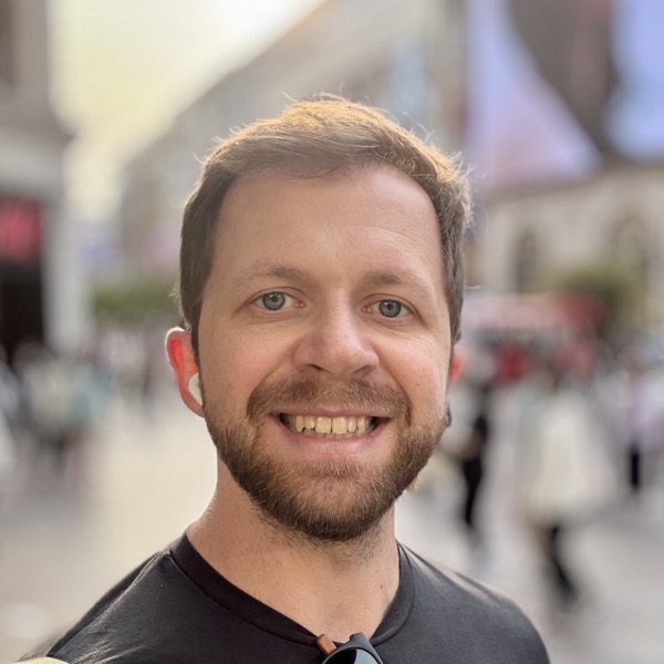 Portrait photo of Geovane Fedrecheski, smiling, on a city street.